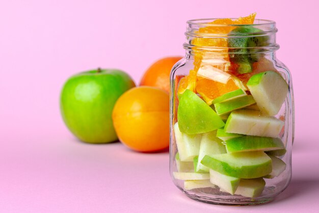 Cerrar en un tazón de vidrio con trozos de fruta fresca