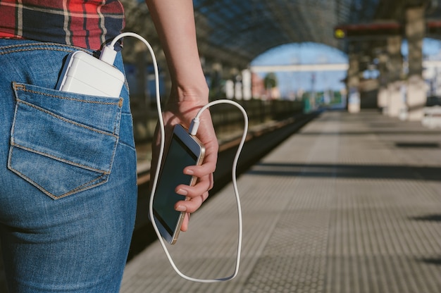 Cerrar en el teléfono móvil en blanco con banco de energía