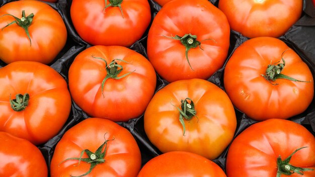 Cerrar la textura de la vista superior de tomates rojos en caja en el mercado local