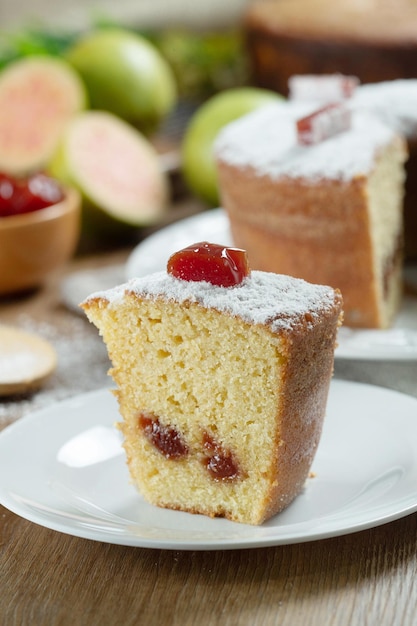 Cerrar un trozo de pastel de maíz brasileño hecho con un tipo de harina de maíz Fuba relleno con pasta de guayaba En una mesa de fiesta de madera Dulces típicos del festival de junio Pastel de harina de maíz