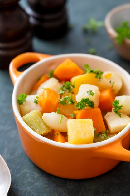 Cerrar tubérculos horneados en un tazón de naranja Comida vegana