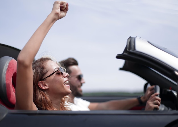 Cerrar upa mujer joven con su novio en un coche descapotable