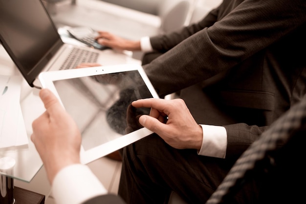 Cerrar upbusinessman usando tableta digital en officepeople y tecnología