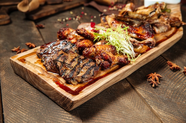 Cerrar en una variedad de carnes asadas en la tabla de madera