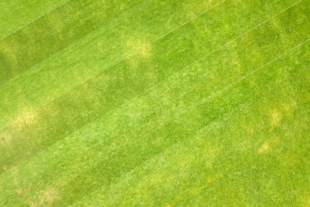 Cerrar vista aérea de la superficie de la hierba verde recién cortada en el estadio de fútbol en verano