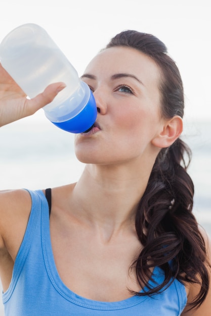 Cerrar vista de agua potable de la mujer después de hacer ejercicio