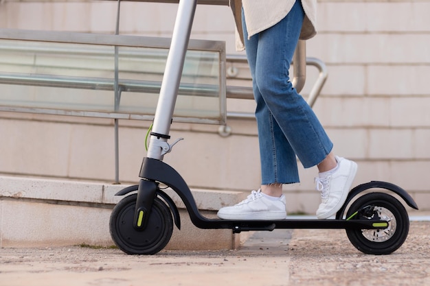 Cerrar vista baja de piernas y pies de mujer joven vistiendo jeans y zapatillas de deporte en la ciudad Concepto de vida de la ciudad