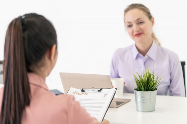 Cerrar la vista de la entrevista de trabajo centrada en la mujer que entrega el currículum con la oficina