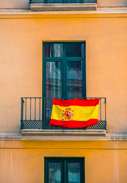 Foto cerrar vista de fachada con ventanas y banderas españolas.