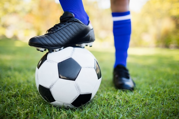 Cerrar vista de globo debajo de botas de fútbol en el parque