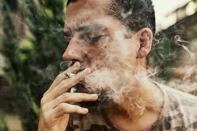 Cerrar vista del hombre fumar marihuana cigarrillo al aire libre