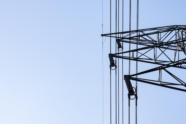 Cerrar la vista inferior del brazo colgante del cable de la torre de transmisión eléctrica bajo el cielo azul limpio con espacio de copia