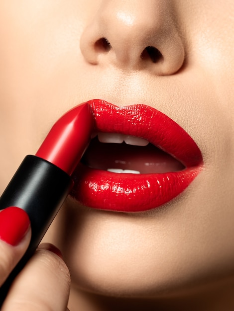 Cerrar vista de labios de mujer hermosa con lápiz labial rojo. Maquillaje de moda. Cosmetología, farmacia o concepto de maquillaje de moda.