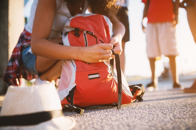 Foto cerrar vista de una mochila turística y una niña cerrándola