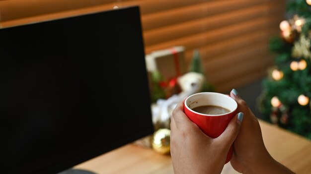 Cerrar vista mujer sosteniendo una taza de café caliente.