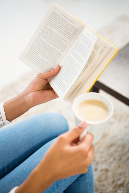 Foto cerrar vista de mujer sosteniendo la taza de café y libro