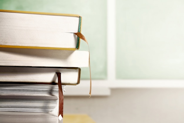 Cerrar vista de pila de libros sobre la mesa de madera con fondo de pizarra