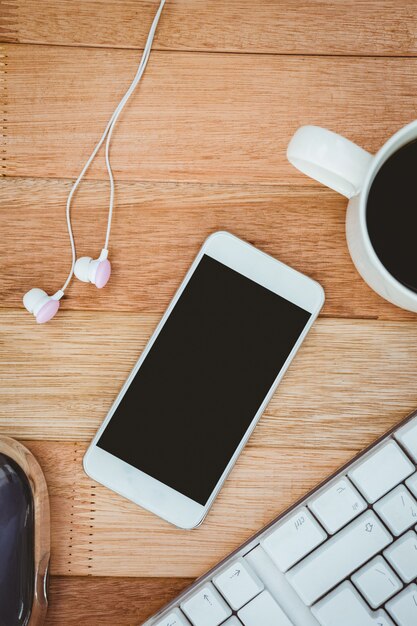 Cerrar vista de smartphone blanco con taza de café