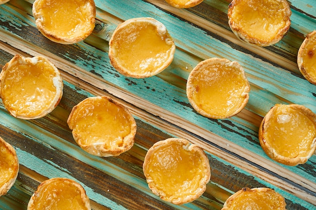 Cerrar vista sobre sabroso pastel de nata - pasteles de tarta de huevo de crema portuguesa espolvoreado con canela en la mesa de madera. Panadería.