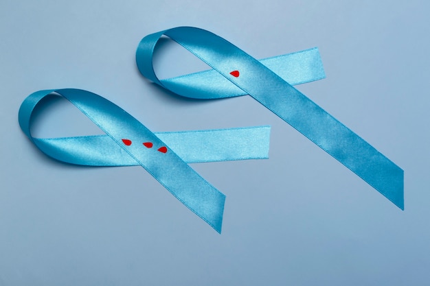 Cerrar la vista superior del concepto para el Día Mundial de la Diabetes el 14 de noviembre. Cinta azul con gotas de sangre sobre un fondo azul.