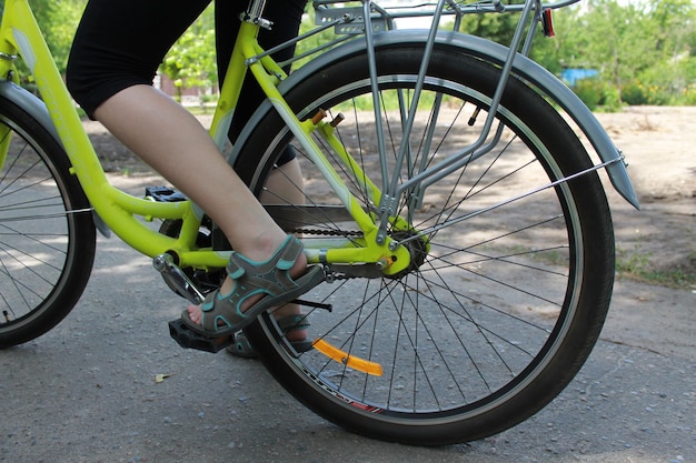 Cerrar vista trasera de ángulo bajo chica pedaleando bicicleta