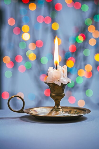 Foto cerrar vista en vela en candelabro en mesa azul y fondo de bokeh