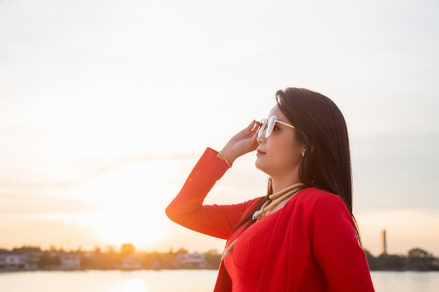 Cerrar womman asiática en una chaqueta roja con gafas de sol