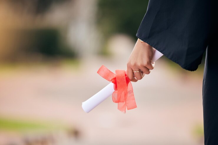 Foto certificado de diploma e mão de estudante em close-up na formatura da faculdade ou realização educacional celebração de estudo e pessoa com sucesso na universidade com prêmio de grau e bolsa de estudos