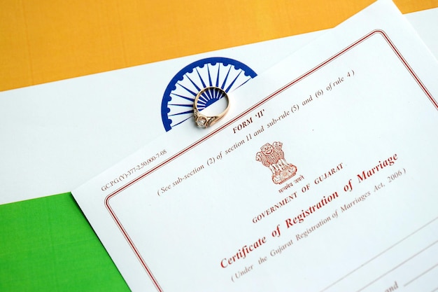 Certificado indio de registro de matrimonio documento en blanco y anillo de bodas en bandera de cerca