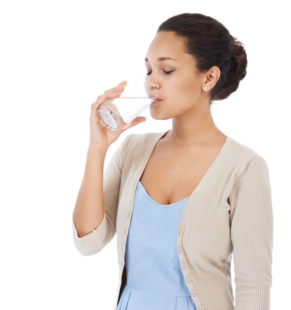 Certificando-se de beber água suficiente Jovem mulher bebendo um copo de água isolado no branco