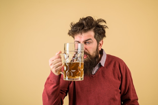 Foto cervecero macho sostiene vaso con cerveza oktober fest degustación de cerveza recién elaborada cervecera sostiene vidrio con