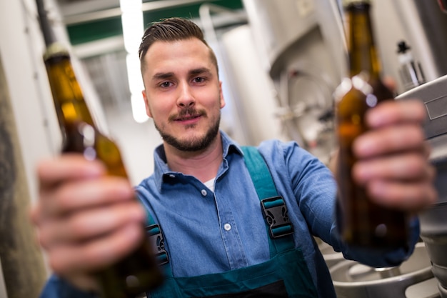 Cervecero sosteniendo dos botellas de cerveza