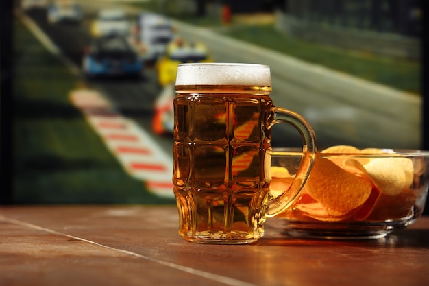 Cerveja com lanche em uma mesa contra o conceito de esporte e entretenimento de fundo de corrida de fórmula um