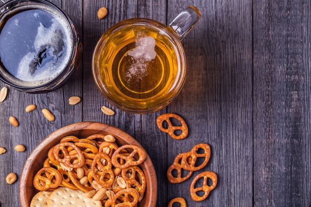 Foto cerveja com pretzels e biscoitos em uma tigela