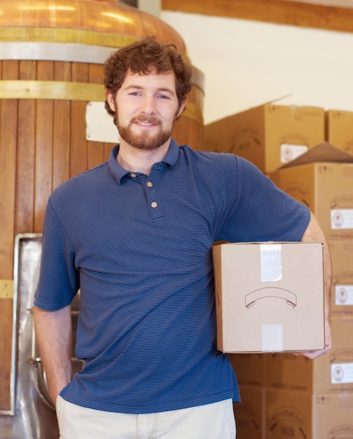 Cerveja de retrato e caixa com um homem em uma cervejaria para a produção de embalagens e entrega de álcool Logística de armazém e indústria com um cervejeiro masculino em uma fábrica para levantamento ou envio de estoque