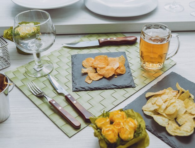 Cerveja e batatas fritas na grande mesa branca