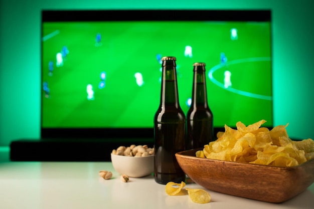 Cerveja e lanches em fundo de tv jogo de futebol.