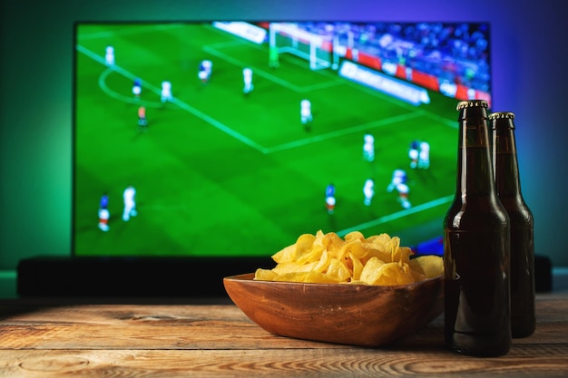 Cerveja e lanches em fundo de tv jogo de futebol.