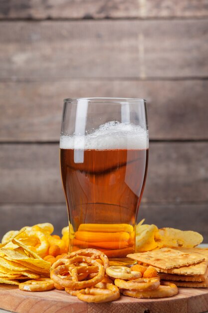 Cerveja e lanches na mesa de madeira.