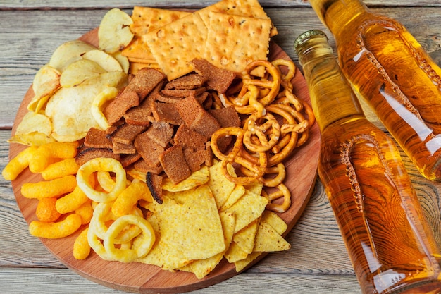 Cerveja e lanches na mesa de madeira.