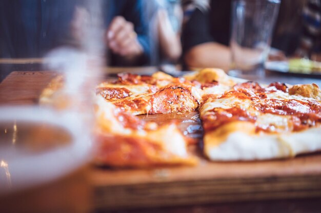 Foto cerveja e pizza rústica servida na mesa.