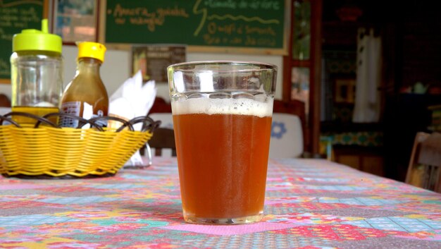Foto cerveja em copo na mesa.
