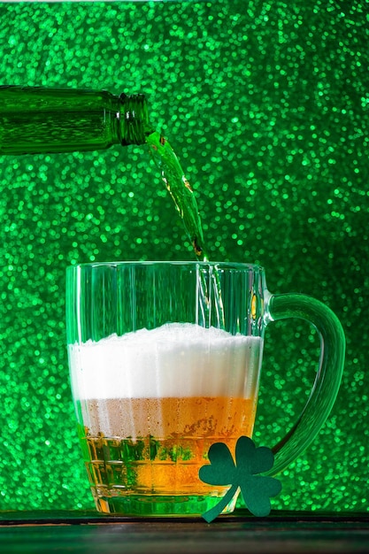 Cerveja está derramando em uma caneca em um fundo verde Celebrando o dia de São Patrício Bebida tradicional irlandesa