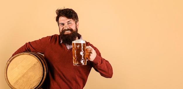 Cervejeiro feliz com caneca de cerveja e equipamento de barril de madeira para preparação do conceito de cervejaria de cerveja