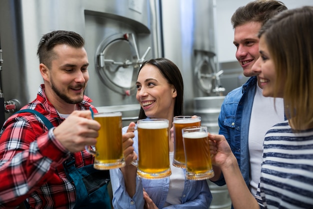 Foto cervejeiros que brindam cervejas na cervejaria