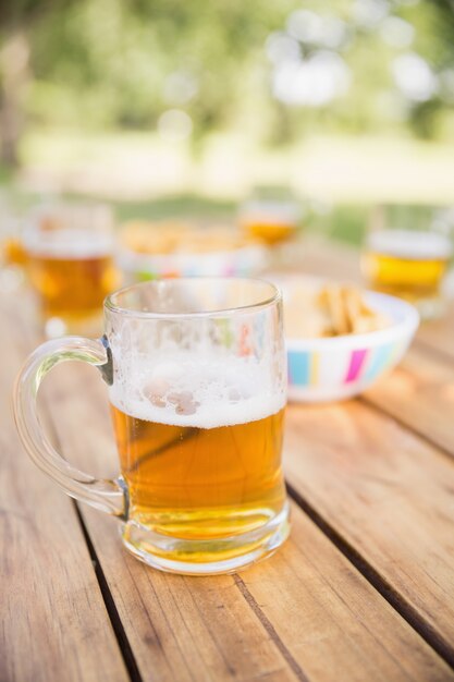 Cerveza y aperitivos en la mesa de picnic