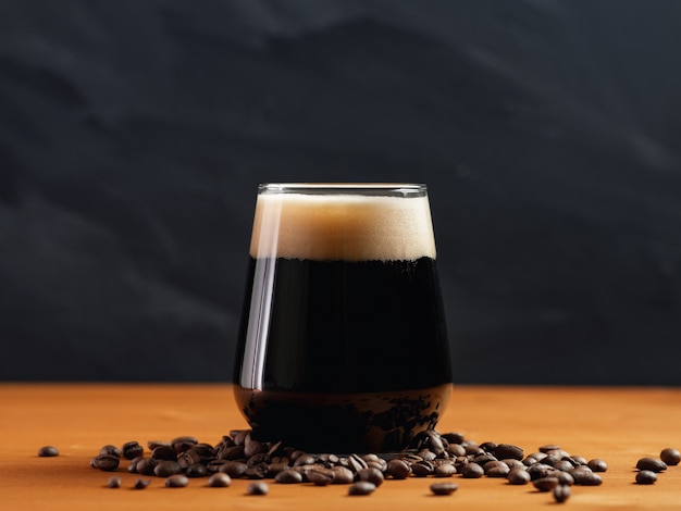 Cerveza artesanal café stout en un vaso sobre una mesa de madera