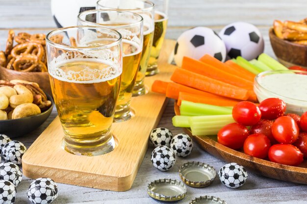 Cerveza de barril y bocadillos salados en la mesa para la fiesta de fútbol.