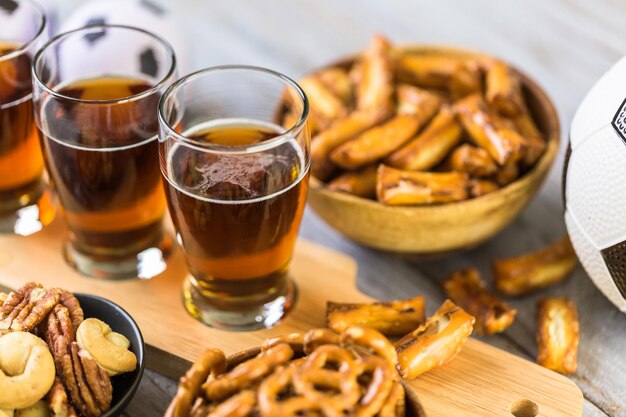 Cerveza de barril y bocadillos salados en la mesa para la fiesta de fútbol.