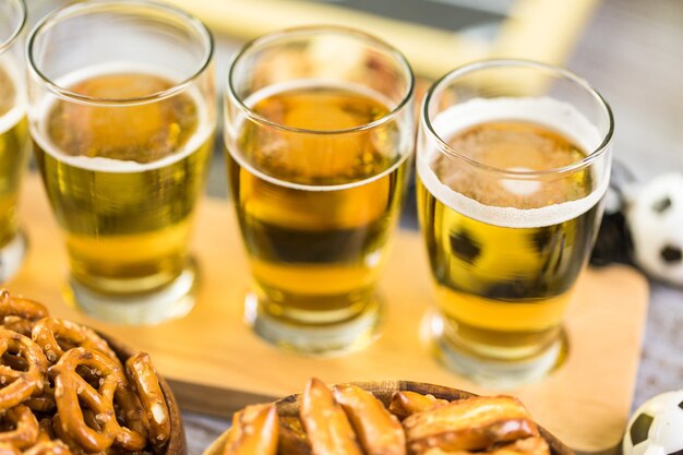 Cerveza de barril y bocadillos salados en la mesa para la fiesta de fútbol.